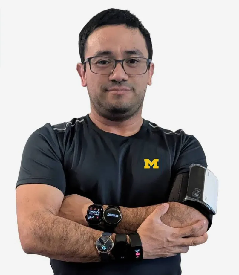 Gabriel wearing several smartwatches and an upper-arm device during device testing.